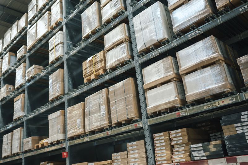 rows of shelves filled with boxes inside large warehouse, ideal for logistics and supply chain visuals, ecommerce fulfillment centers, industrial inventory management, and global distribution networks