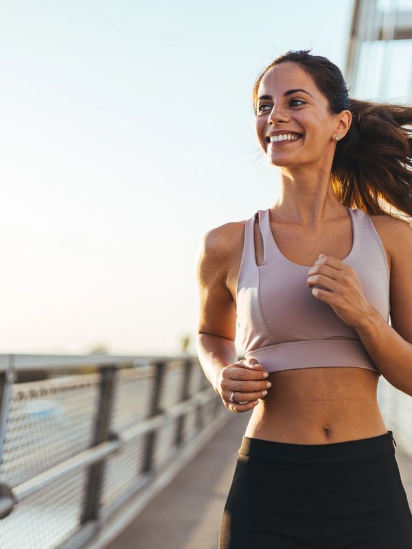 Smiling woman jogging outside.
