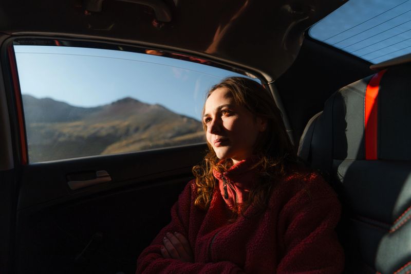 Serene woman traveling in car on passenger seat in Peruvian Andes