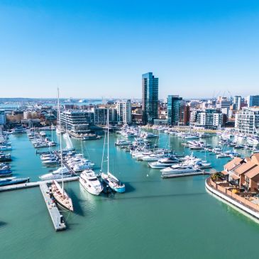 Marina filled with yachts and boats under clear blue sky.