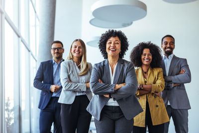 Confident diverse business team smiling with arms crossed.