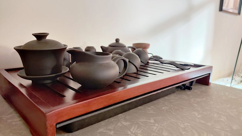 A side view composition featuring finely crafted ceramic teaware, thoughtfully arranged for a traditional Chinese tea ceremony — capturing the graceful lines, textures, and heritage of this timeless ritual