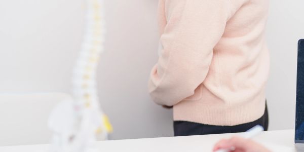 Person holding their lower back in pain.