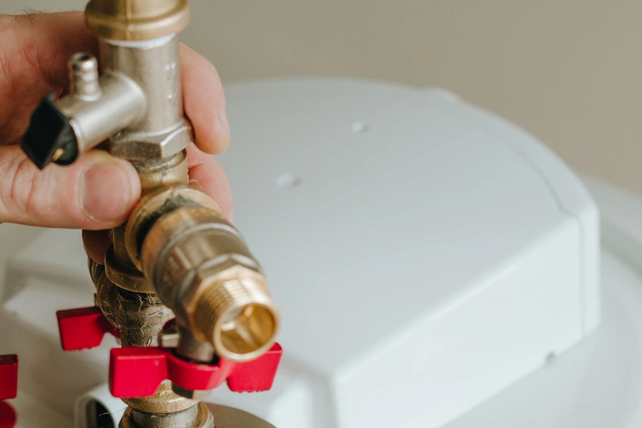 Plumber servicing a water heater valve
