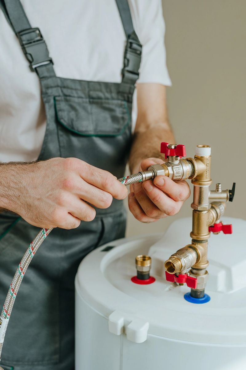 Man fixing water heater. Close-up view of male hands.