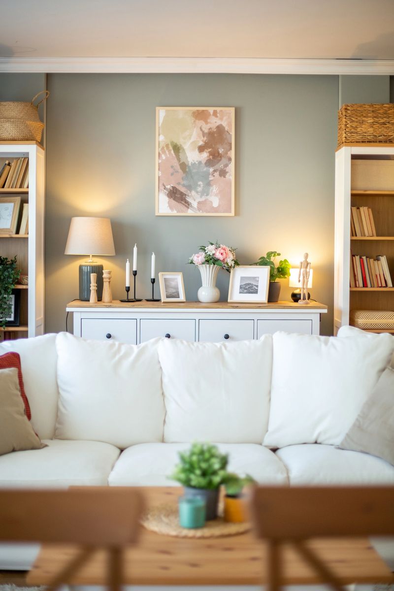 Stylish and cozy living room with white sofa, pastel decorations, and wooden furniture, creating a welcoming atmosphere