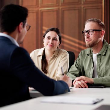 Couple discussing with a professional in a formal office setting.