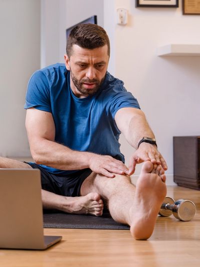 Personne s'étirant devant un écran d'ordinateur