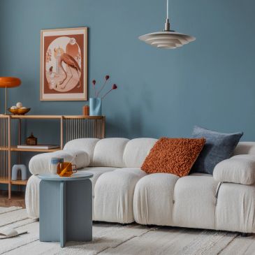 Cozy living room with a white plush sofa and blue accent wall.