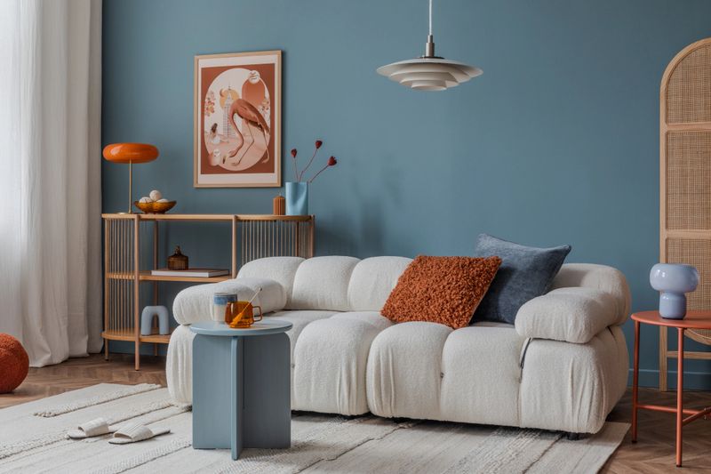 Neutral-toned living room corner with layered textiles, a cushioned sofa, and minimalistic decor for a calm ambiance.