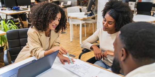 woman showing couple a floor plan