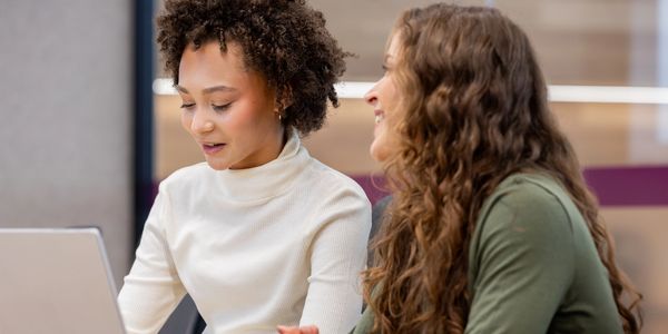 Two women working together on a laptop.