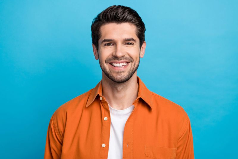 Portrait of positive friendly man beaming smile good mood nice hairstyle isolated on blue color background.