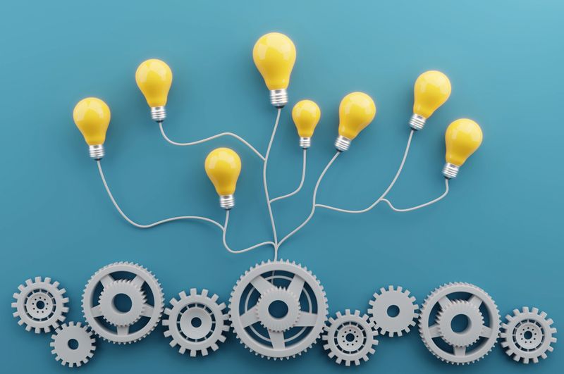 Cogs churn quietly below while bright ideas bloom overhead, capturing how unseen processes power flashes of innovation. It’s a vivid metaphor for teamwork, perseverance, and the hidden machinery behind every breakthrough.