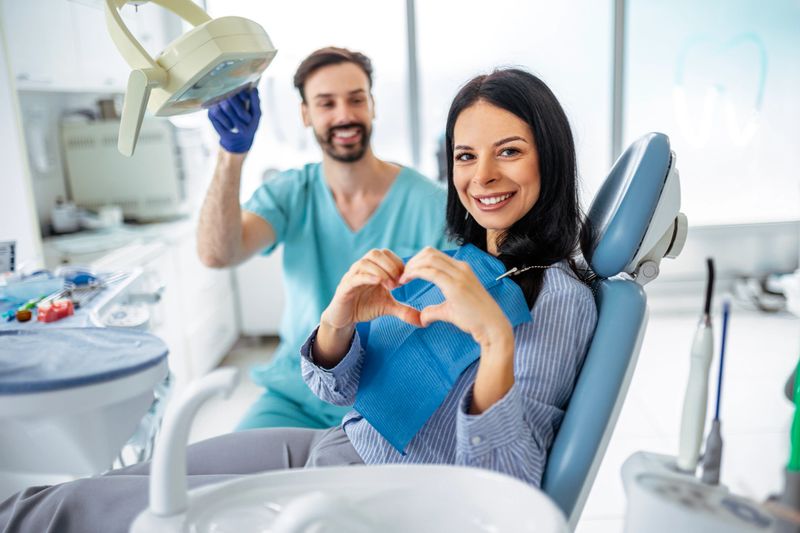 Portrait of happy patient in dental chair with chosen dentist