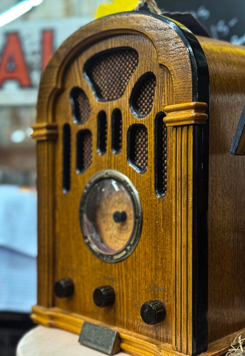 Detailed close-up of a retro wooden radio with an analog tuning dial. Warm lighting and nostalgic design evoke classic charm and timeless technology.