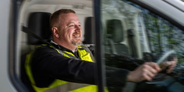 Man smiling while driving a vehicle.