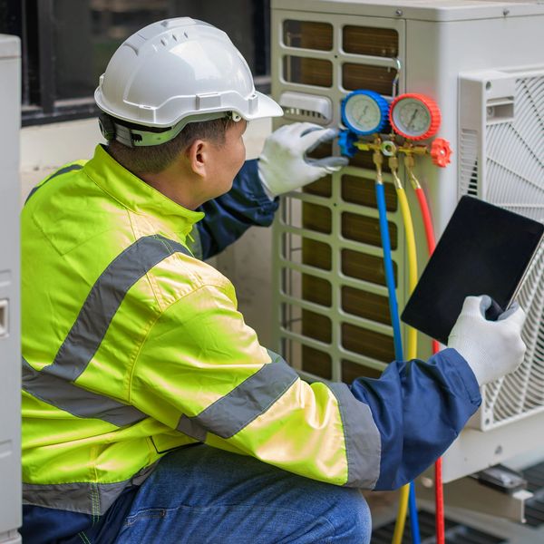 Technician checking air conditioning unit.