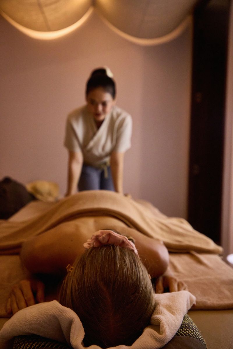 A relaxing spa scene featuring a woman receiving a massage by a therapist in a tranquil, softly lit environment. The setting exudes calmness, wellness, and rejuvenation, ideal for stress relief and tranquility concepts.