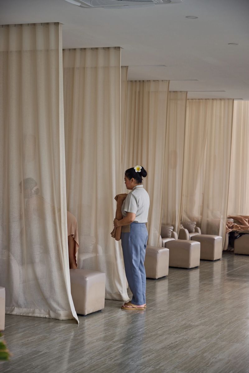 A serene setting inside a spa featuring a staff member holding towels near privacy curtains and a client, conveying relaxation, wellness, and personalized care in a tranquil environment.