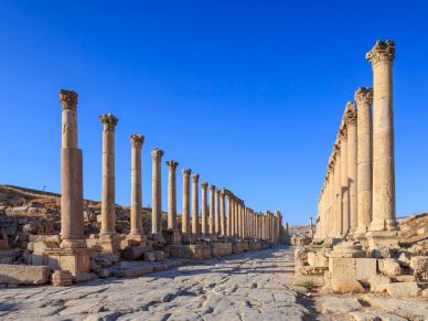 Ruinas antiguas con columnas bajo un cielo azul.