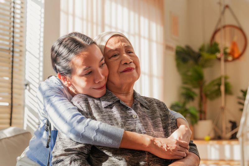 Asian Family, old woman hugging her daughter and cancer with sad people on a sofa in the home living room during recovery. Love, trust or comfort with a sick senior female parent embracing Daughter and sick mother hugging