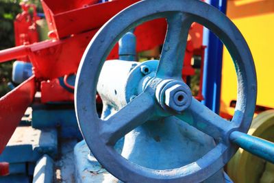 Close-up of a blue metal valve wheel on industrial machinery.