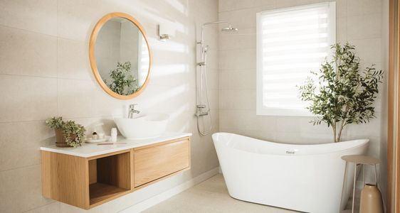 Modern bathroom with dark tiles, a bathtub, and soft lighting.