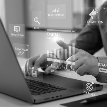 Person using laptop with digital marketing icons overlay.