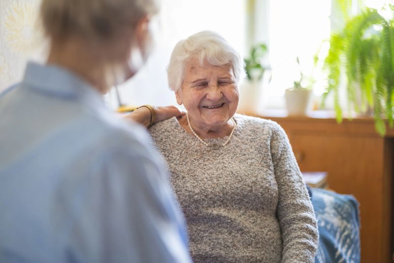 Female home caregiver providing emotional support to an elderly woman