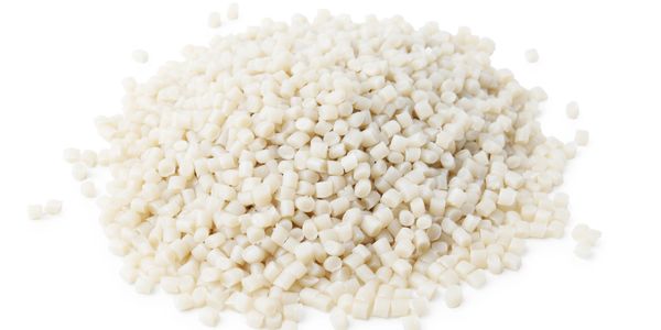 Pile of small beige plastic pellets on a white background.