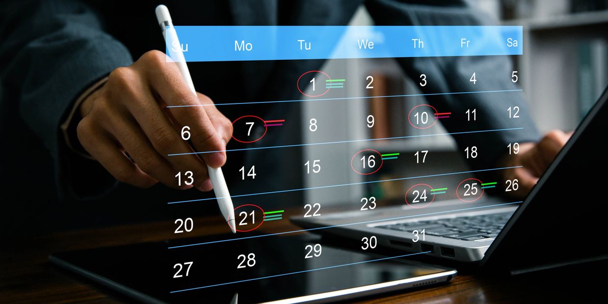 Person marking dates on a digital calendar with a stylus.