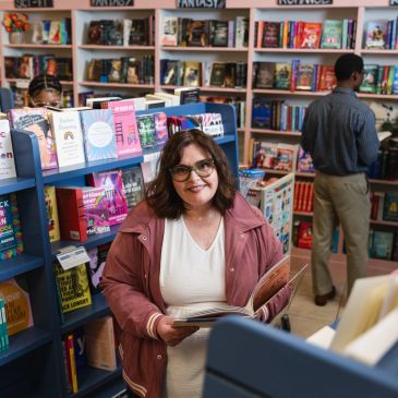 A woman browsing books in a bookstore.