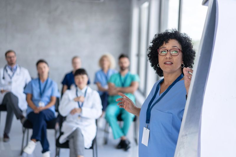 A vibrant training session depicts healthcare professionals actively engaged in learning and discussion with a dynamic presenter.