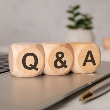 Wooden blocks spelling Q&amp;A on a laptop.