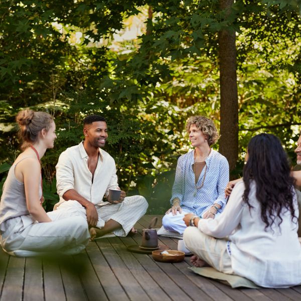 Group of friends sitting outdoors having a conversation.