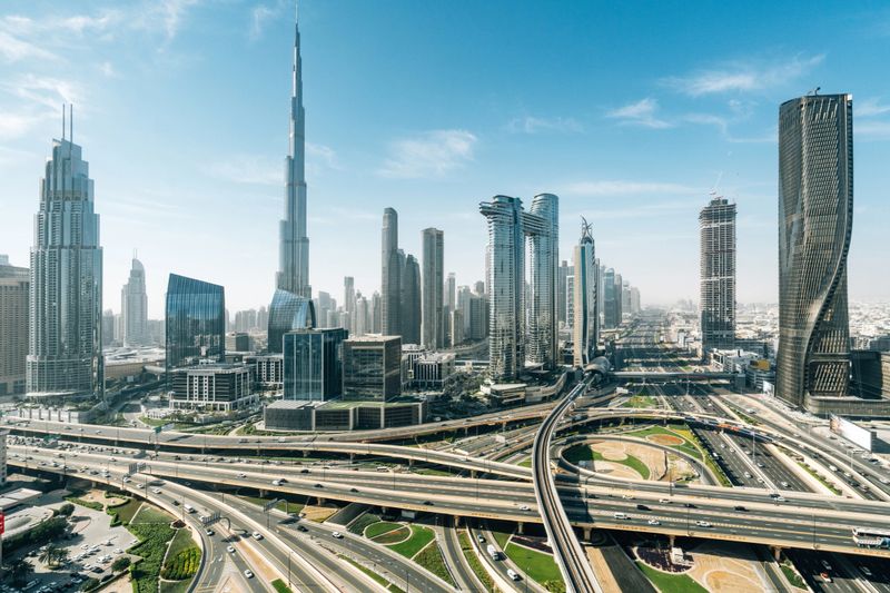 Modern cityscape of Dubai showcasing the iconic Burj Khalifa, towering skyscrapers, and complex highway interchanges