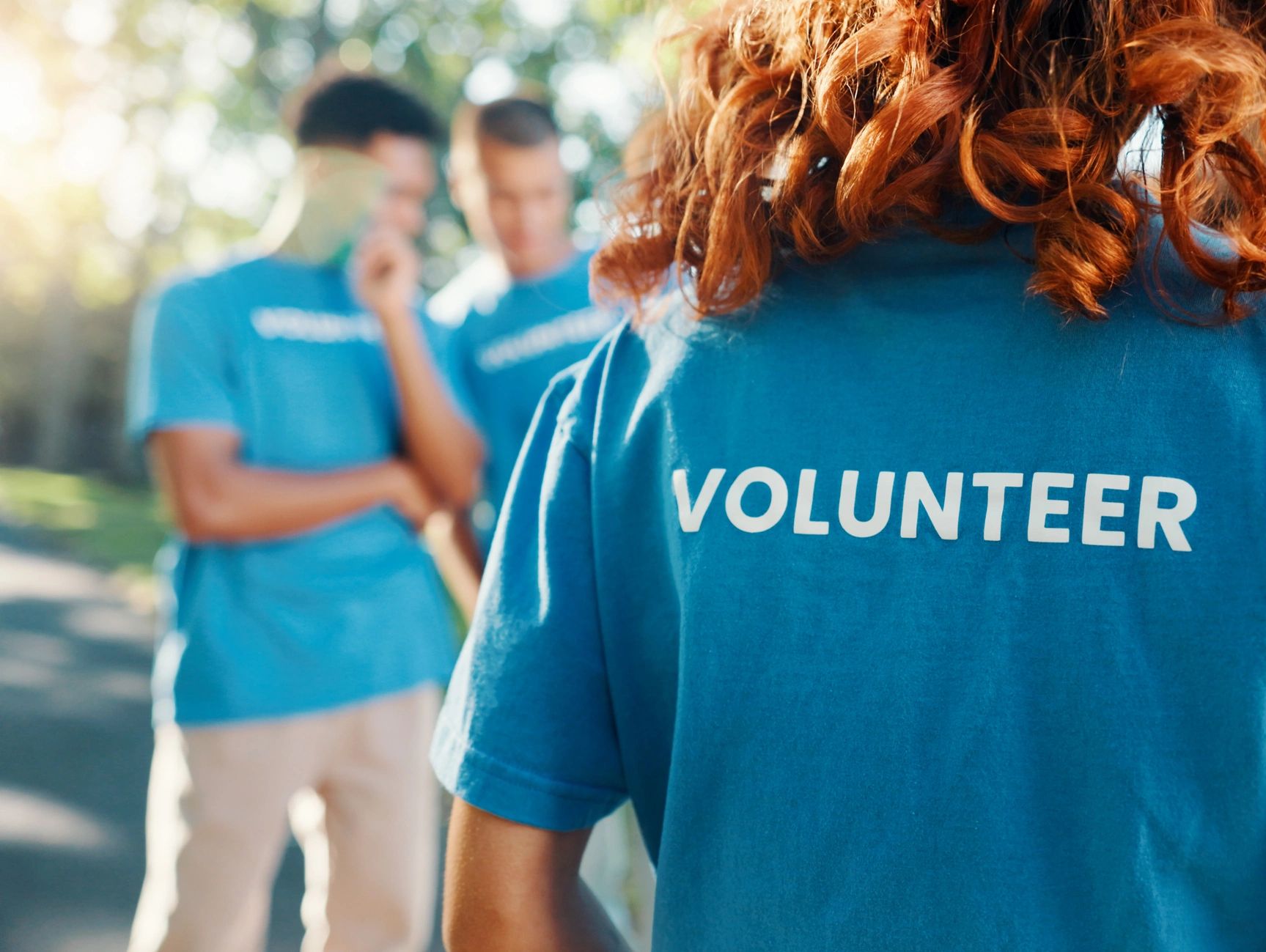Group of volunteers with blue shirts outside.