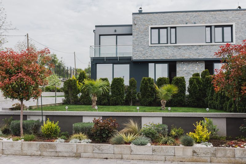 A contemporary residence with a landscaped front garden featuring diverse greenery and clean design elements, showcasing a stylish and neat outdoor aesthetic.