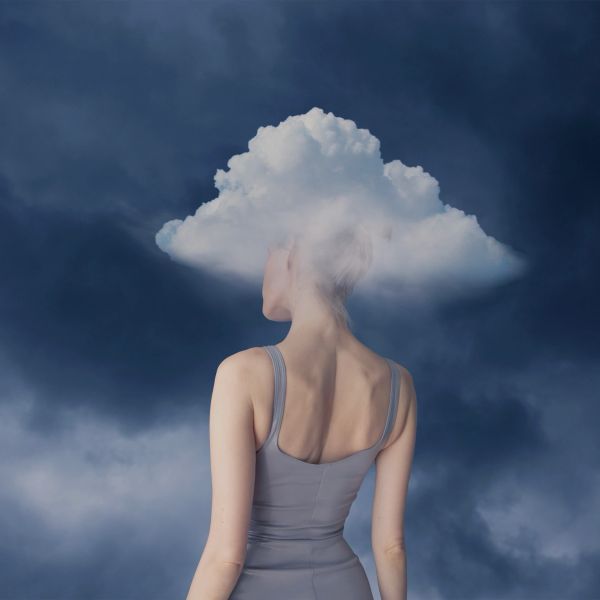 An overwhelmed woman standing with clouds over her head resembles the benefits of trauma-informed counselling for adults in Echuca