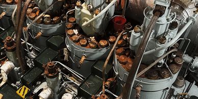 Close-up of an old industrial engine with pipes and rusted components.