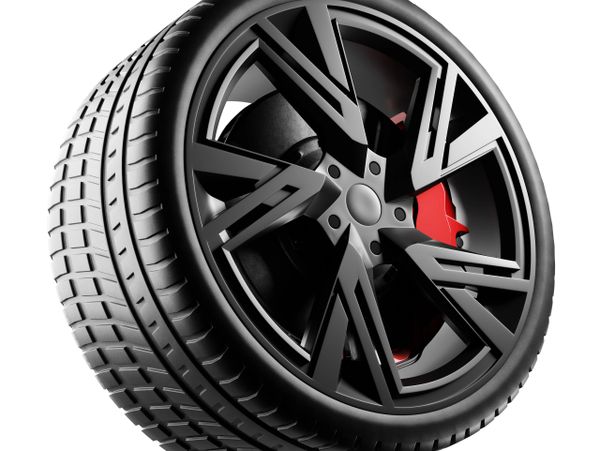 Close-up of a black car tire and wheel with a red brake caliper.