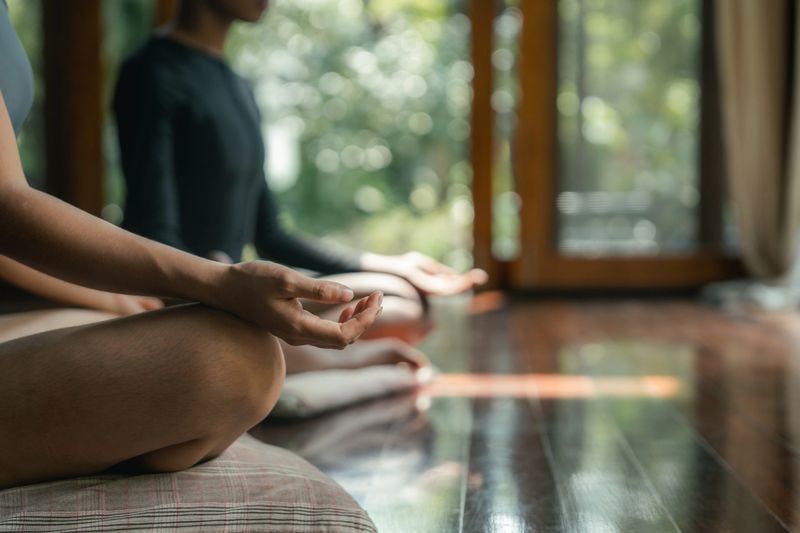 Two female friends practicing meditation at a wellness resort. In this serene setting, they embark on a journey of self-improvement, letting go of stress and embracing a sense of clarity and balance, nurturing both their minds and spirits