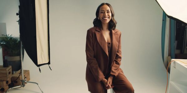 Smiling woman in brown suit in a photography studio.