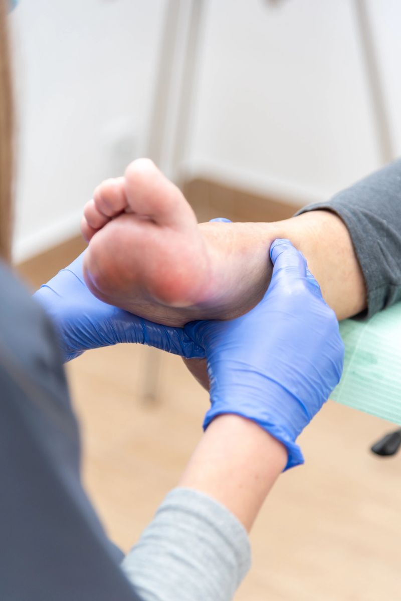 Podiatrist wearing blue gloves carefully examining a patient's foot, delivering expert medical care and attention in a clinical setting