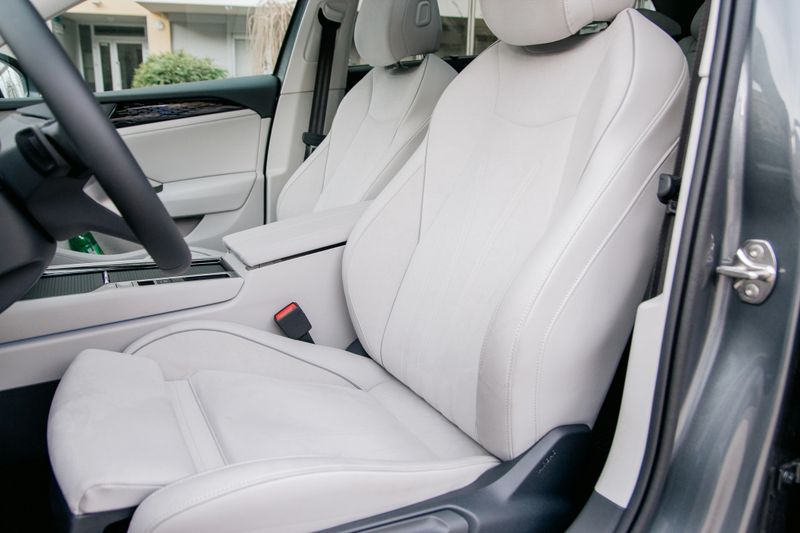 A pristine light gray leather interior showcases the front seats of a car. Modern design, clean lines, and focus on passenger comfort. Stylish vehicle interior.