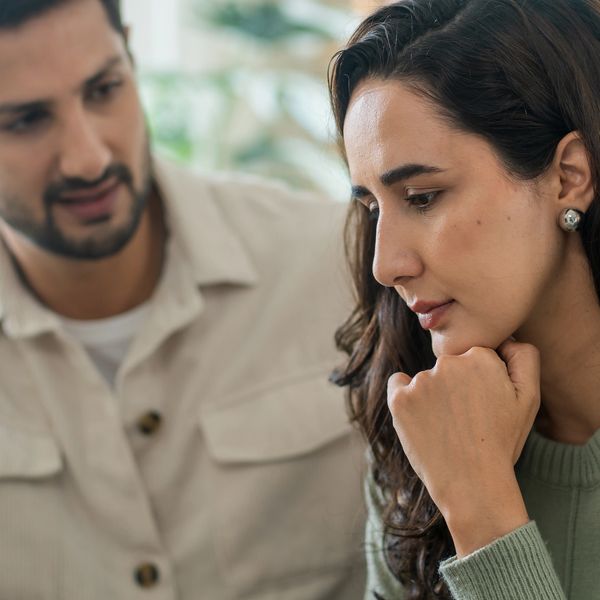 Man comforting a thoughtful woman during a serious conversation.