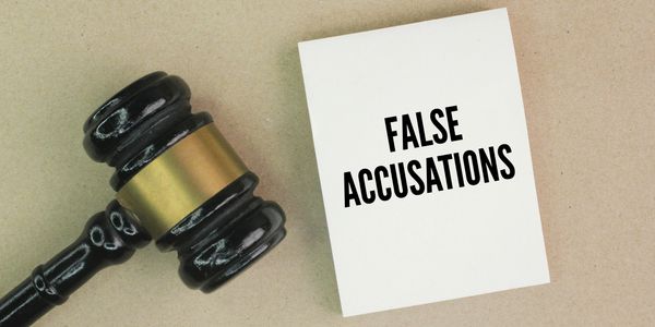 A judge's gavel next to a card that reads 'FALSE ACCUSATIONS'.