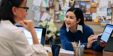 Dos mujeres trabajan juntas usando tecnología.