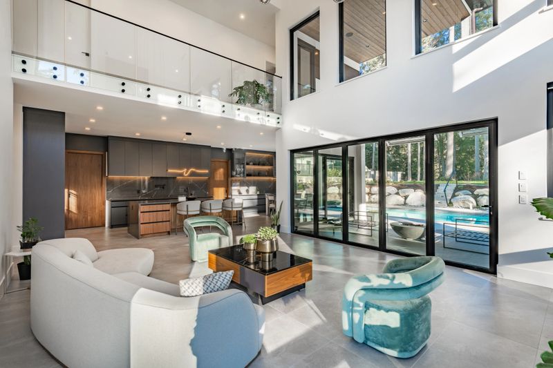 A very large modern contemporary private residence residential home spacious interiors living room, kitchen, office, recreation room, foyer, hallway, floating staircase window wall open to a patio with BBQ and swimming pool. New construction family home